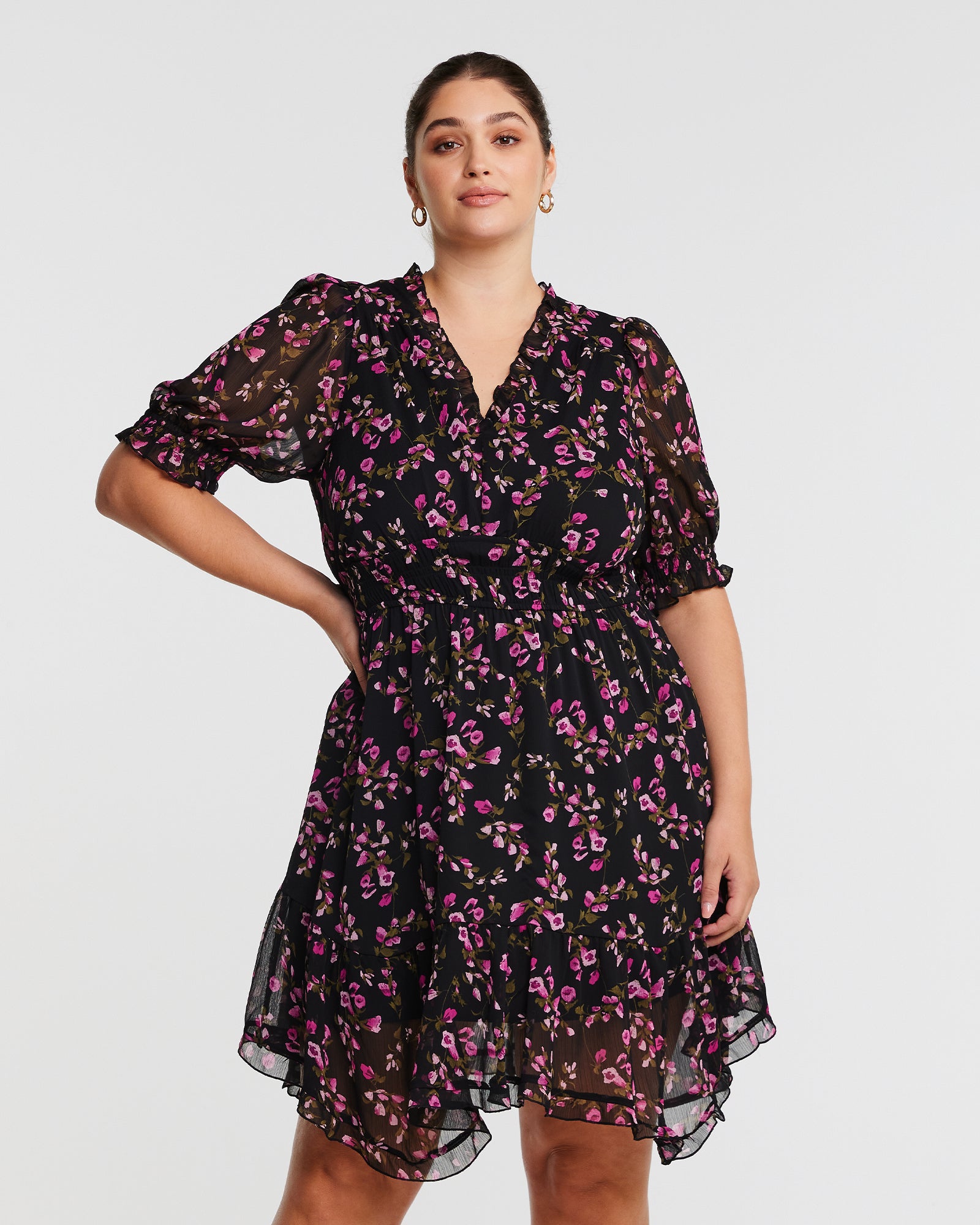 A plus size woman wearing the Tulip Garden Shirred Floral Mini Dress.
