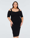 A plus size woman wearing a black cold shoulder Estelle Sacha Dress.