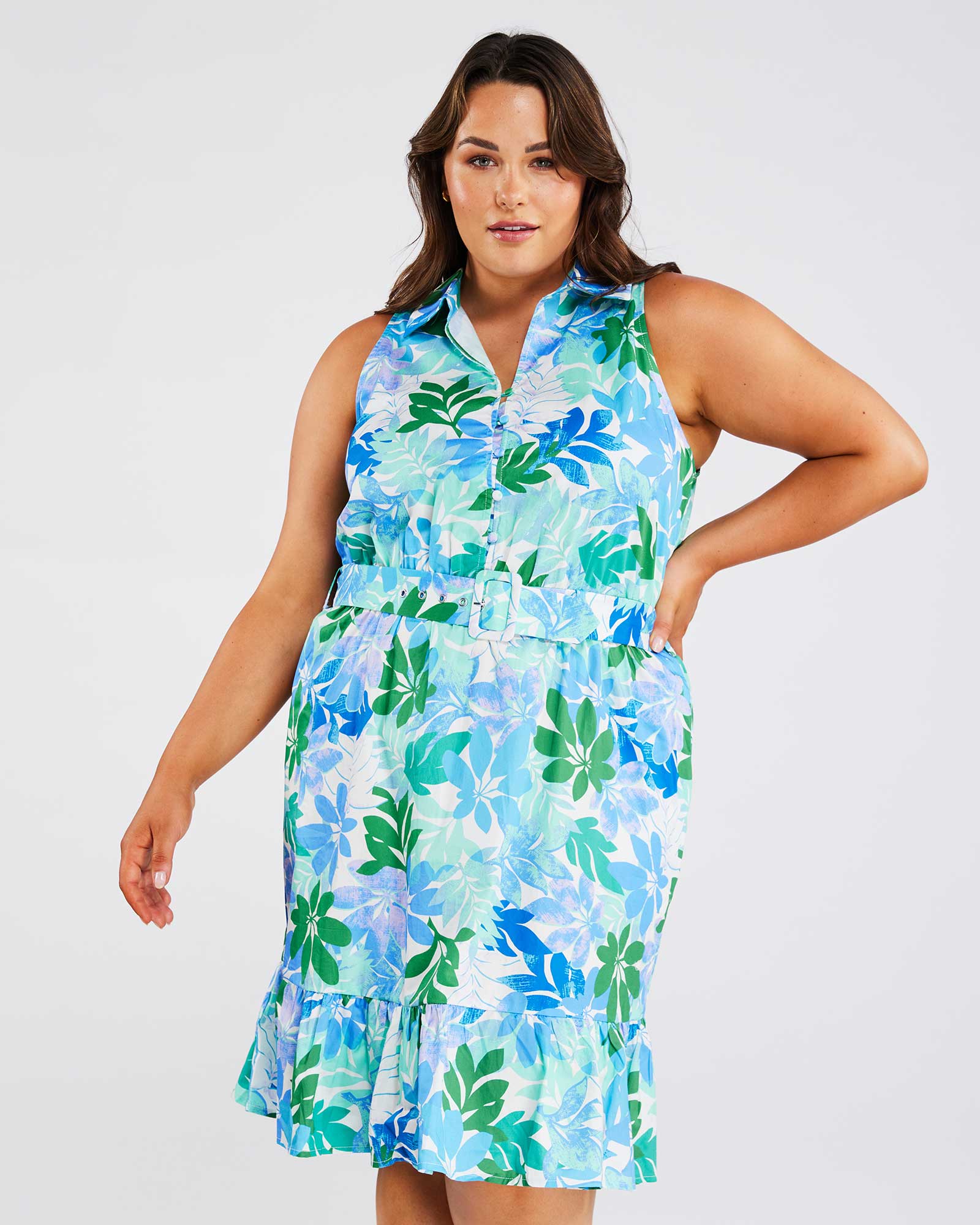 A plus size woman wearing an Estelle Travola Dress in a blue and green floral print.