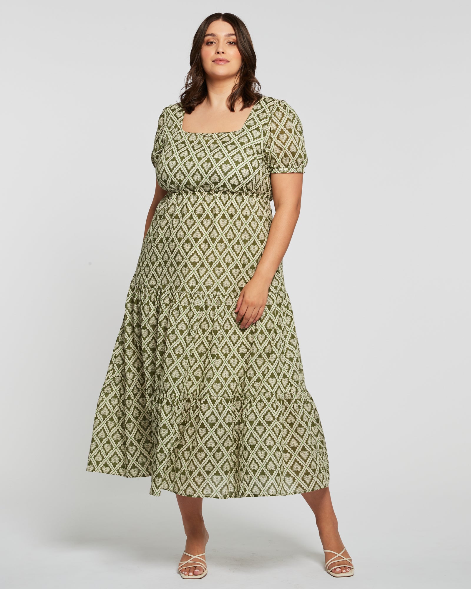 The plus size woman is wearing a Estelle Olive Heart Maxi Dress.