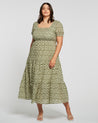 The plus size woman is wearing a Estelle Olive Heart Maxi Dress.