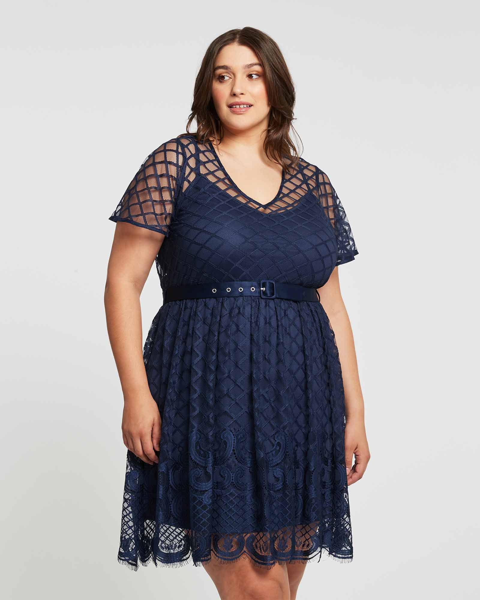 A plus size woman wearing an Estelle Catalina Lace Dress.