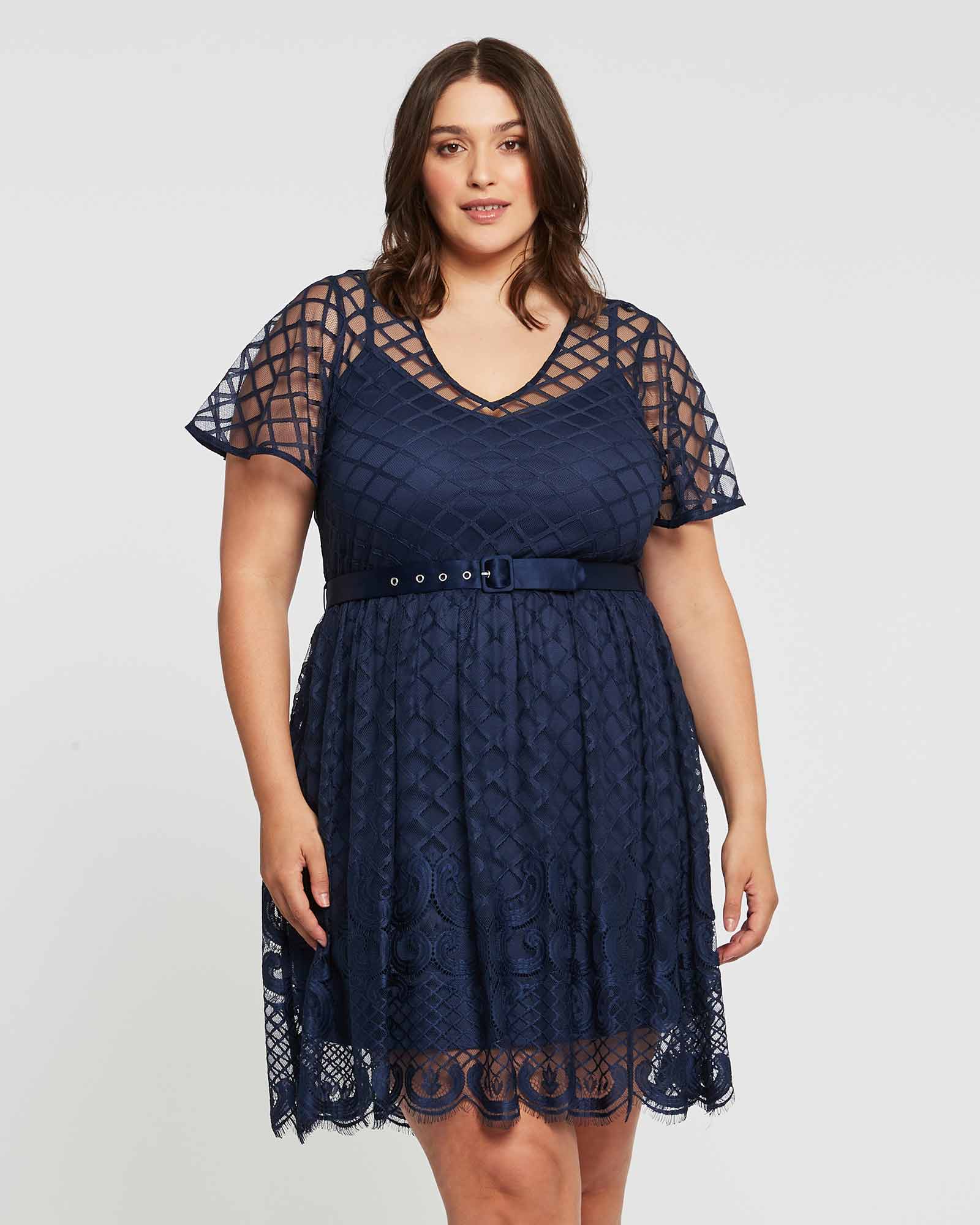 A plus size woman wearing a Estelle Catalina Lace Dress.