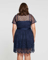 The back view of a plus size woman wearing a Estelle Catalina Lace Dress.