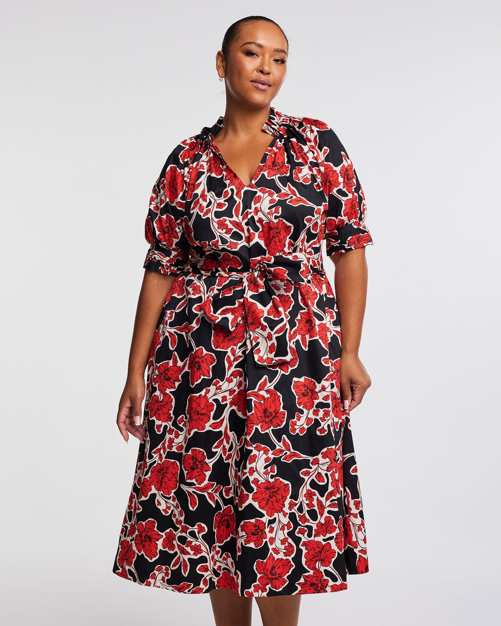 A plus size woman wearing an Estelle Wallflower Dress.