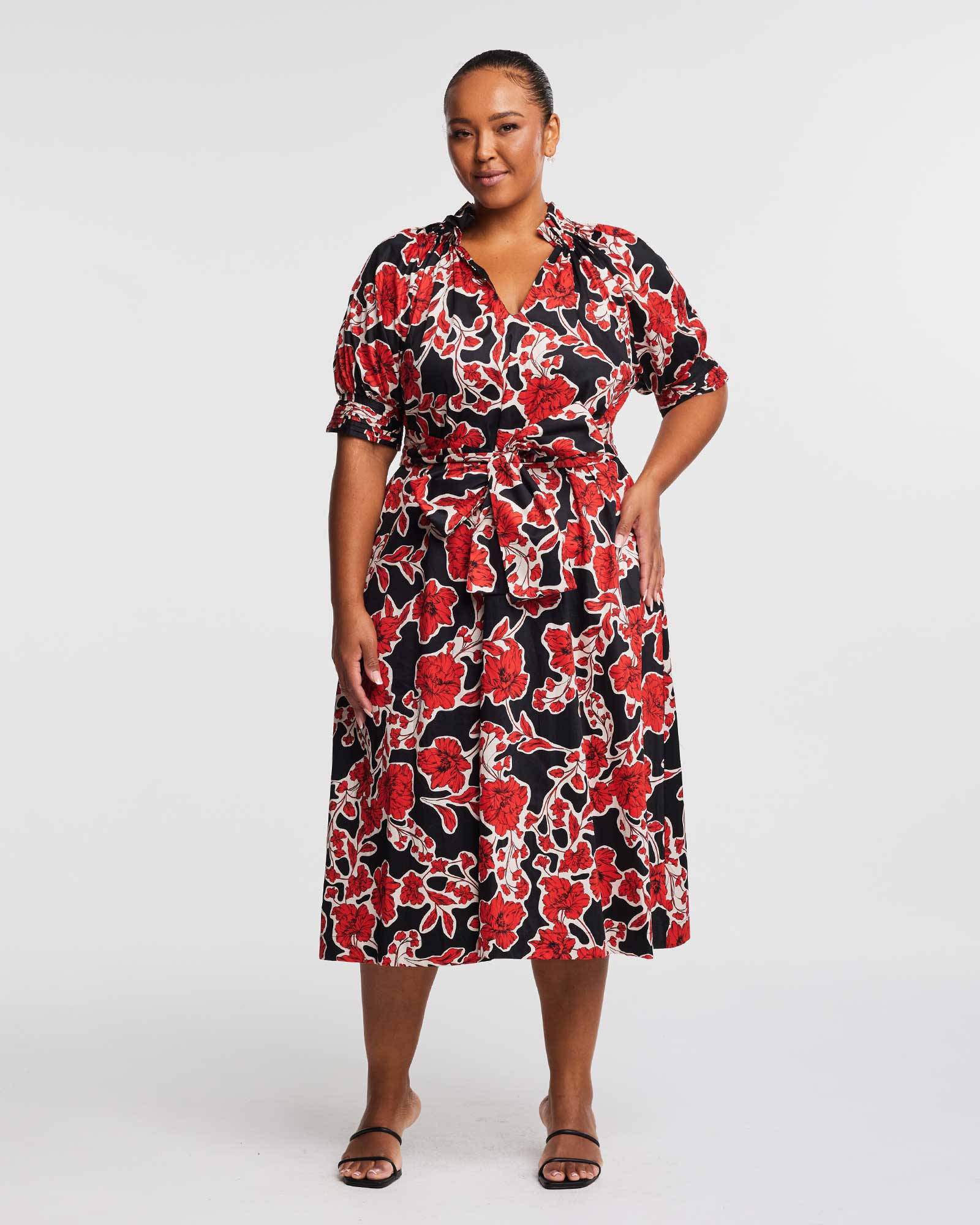 A plus size woman wearing an Estelle Wallflower Dress.
