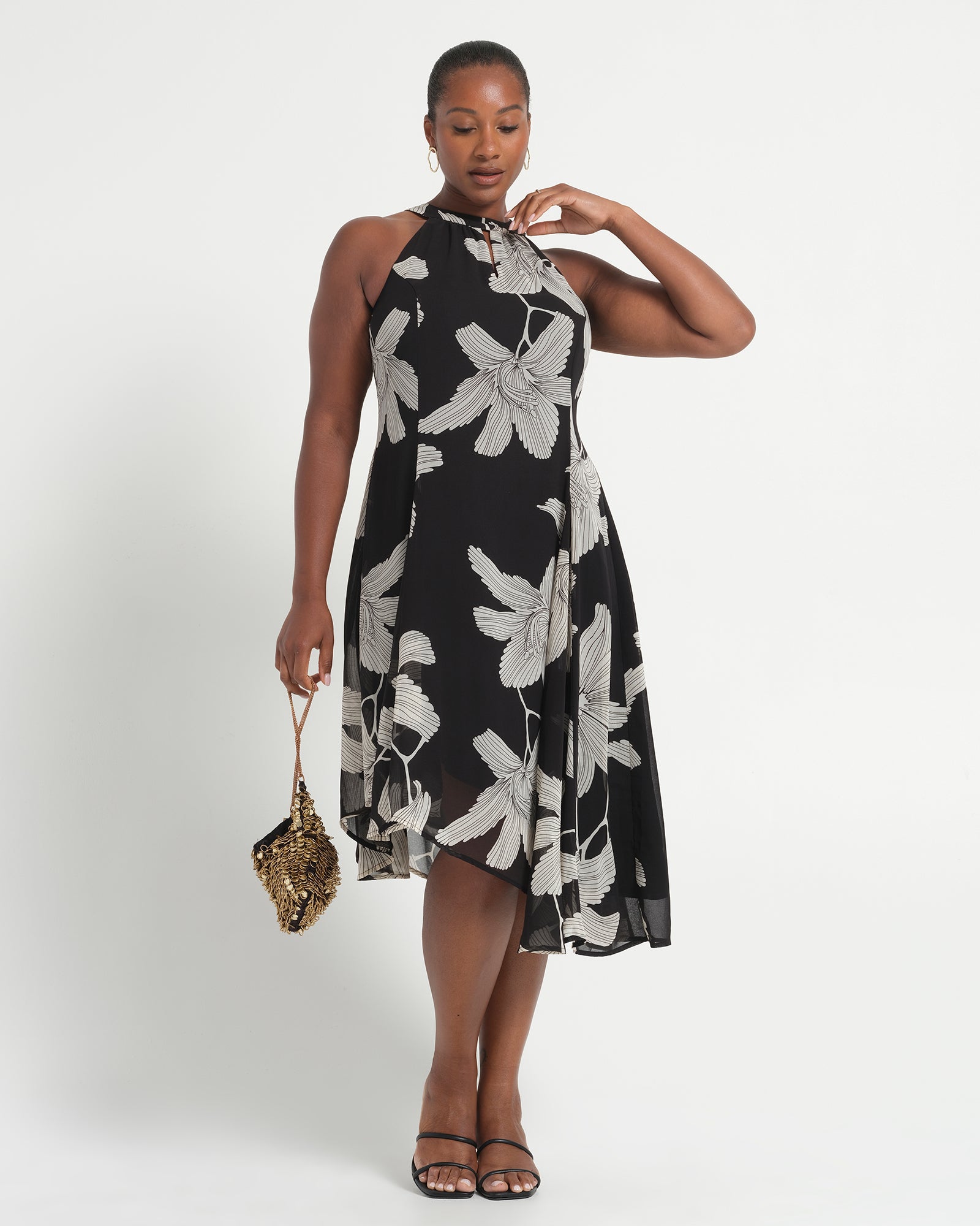 Woman wearing a black floral dress on a white background