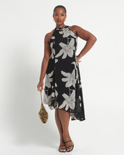 Woman wearing a black dress with white floral patterns on a white background