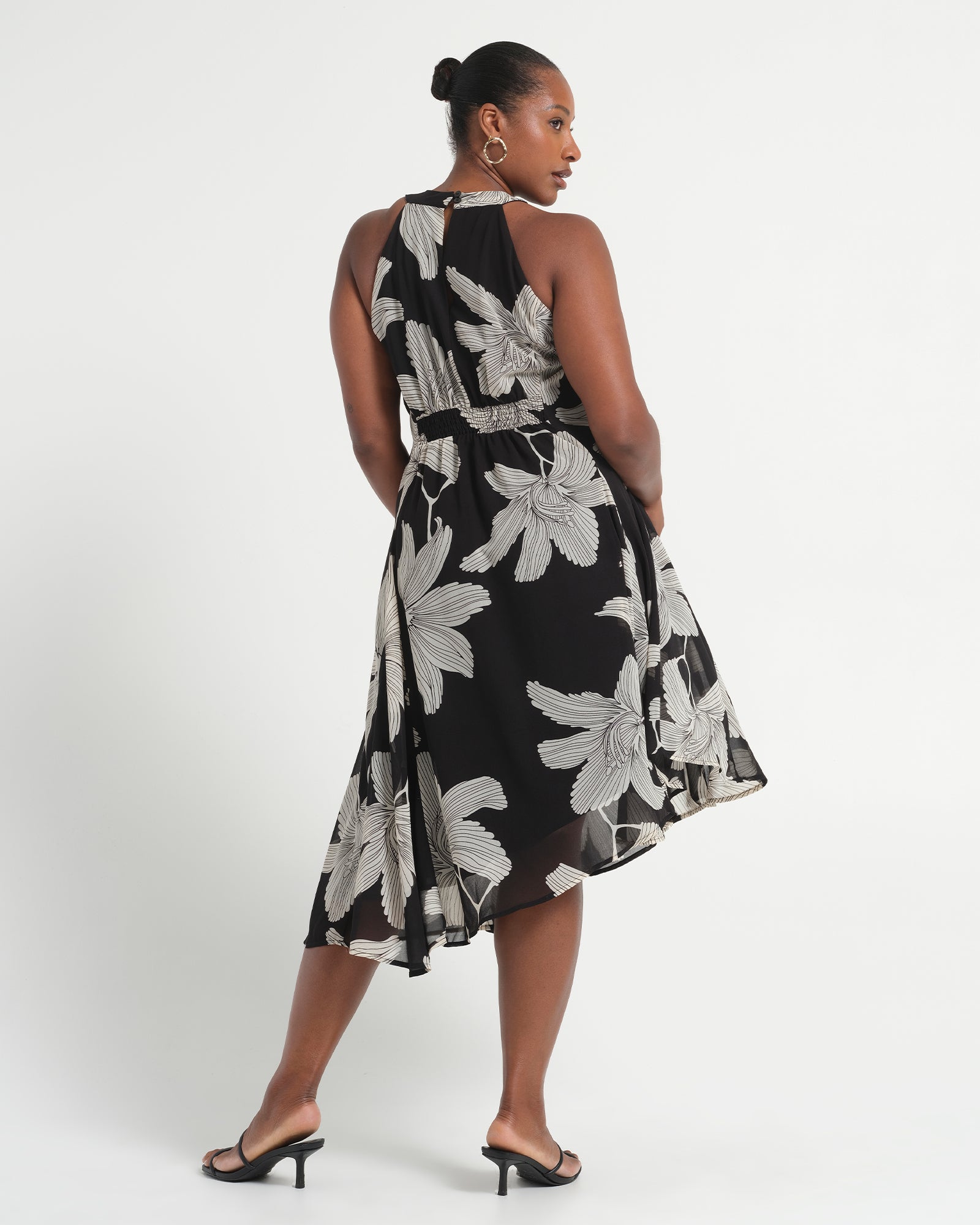 Woman wearing a black floral dress on a white background