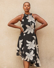 Woman wearing a black floral dress against a beige background