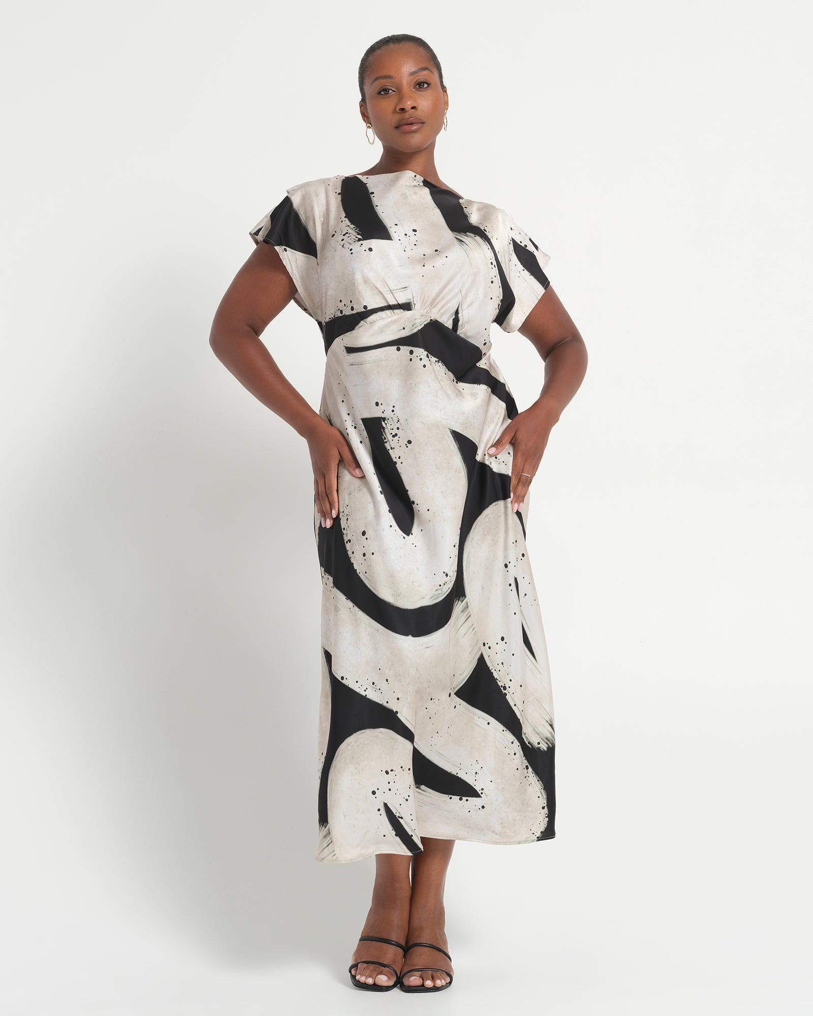 Woman wearing a black and white patterned dress on a white background
