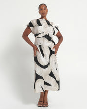 Woman wearing a black and white patterned dress on a white background