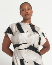 Woman wearing a black and white dress with abstract patterns on a white background