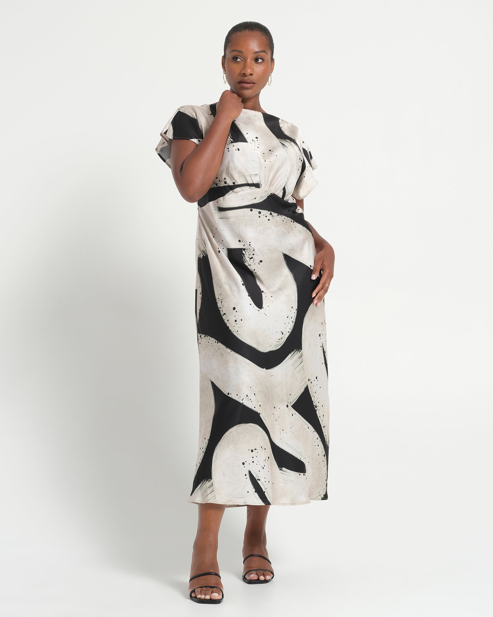 Woman wearing a black and white patterned dress on a white background