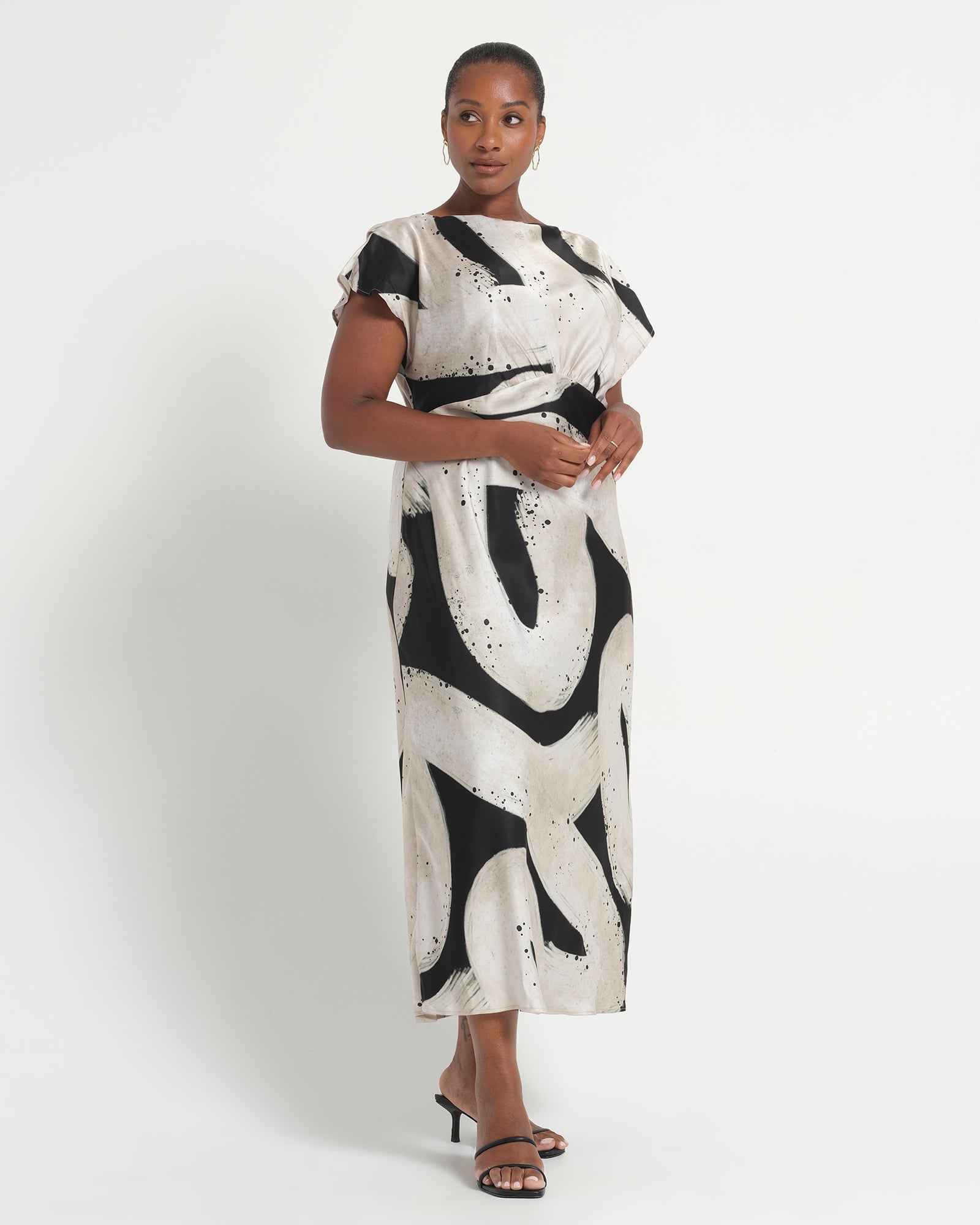 Woman wearing a black and white patterned dress on a white background