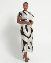 Woman wearing a black and white patterned dress on a white background