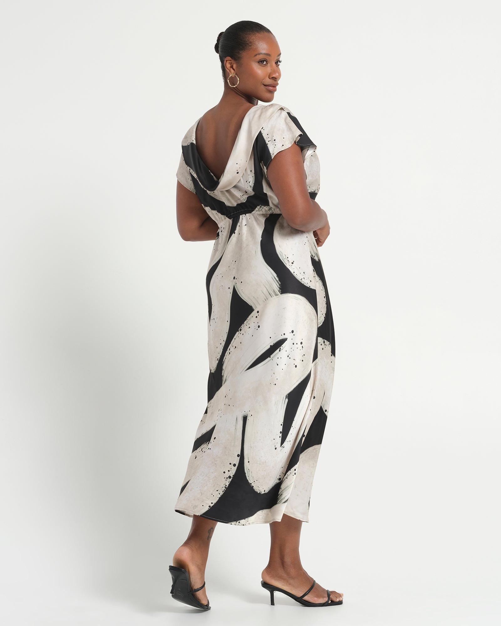 Woman wearing a black and white patterned dress on a white background