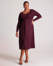 Woman wearing a burgundy dress with long sleeves on a white background