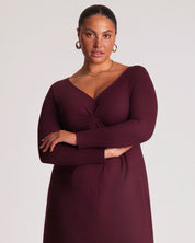 Woman wearing a burgundy dress against a plain background