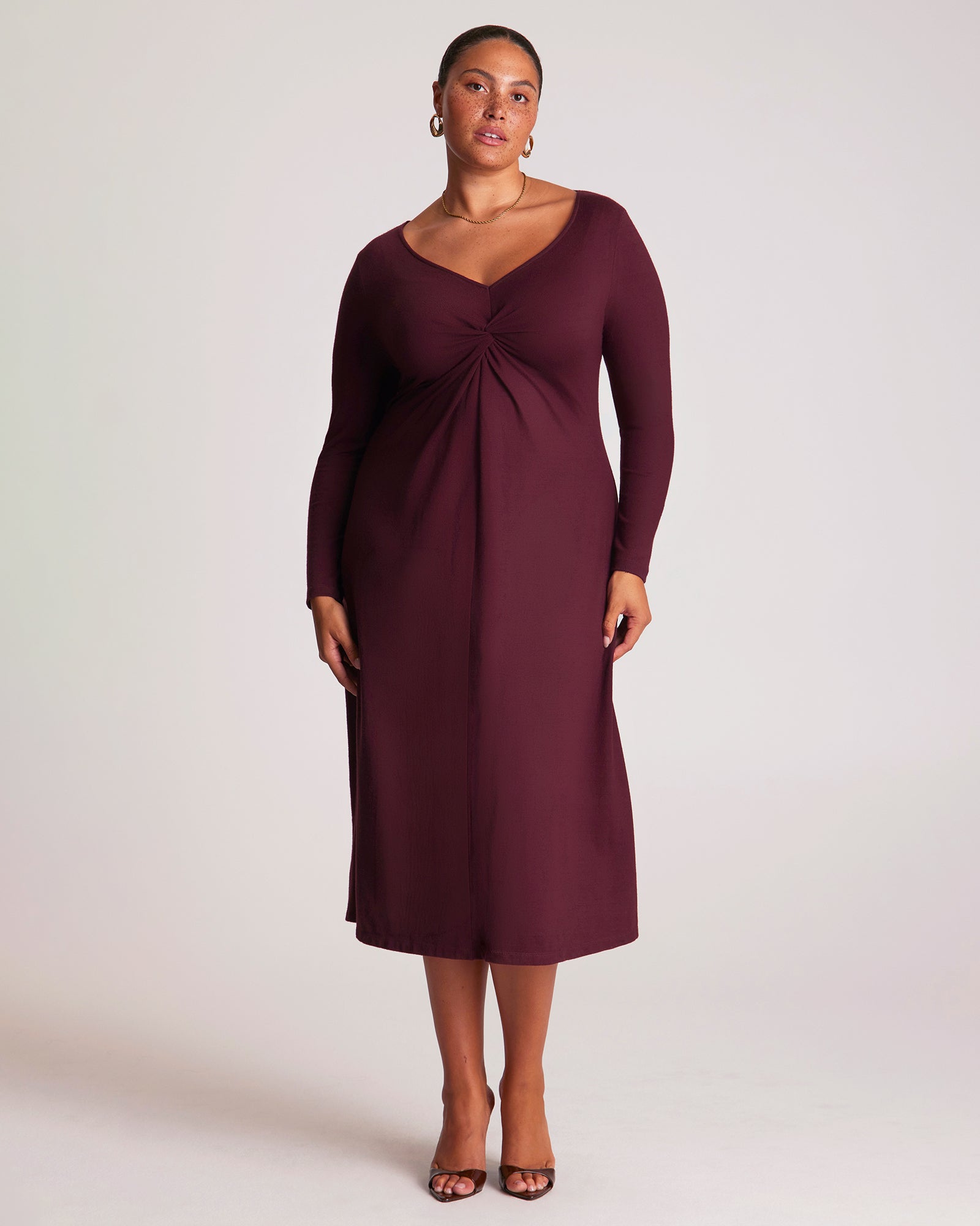 Woman wearing a burgundy dress against a white background