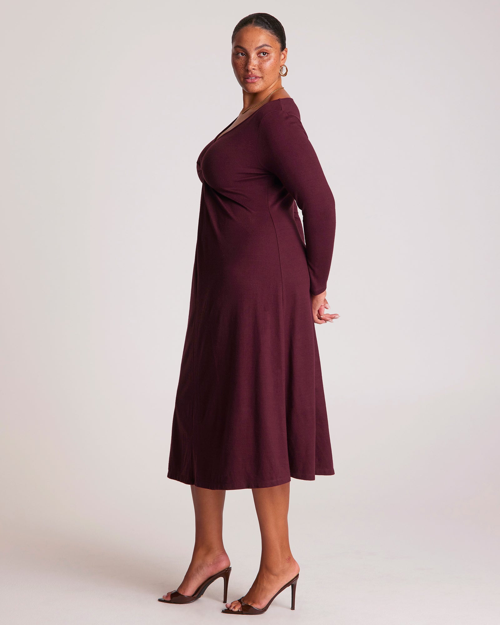 Woman wearing a burgundy dress against a white background