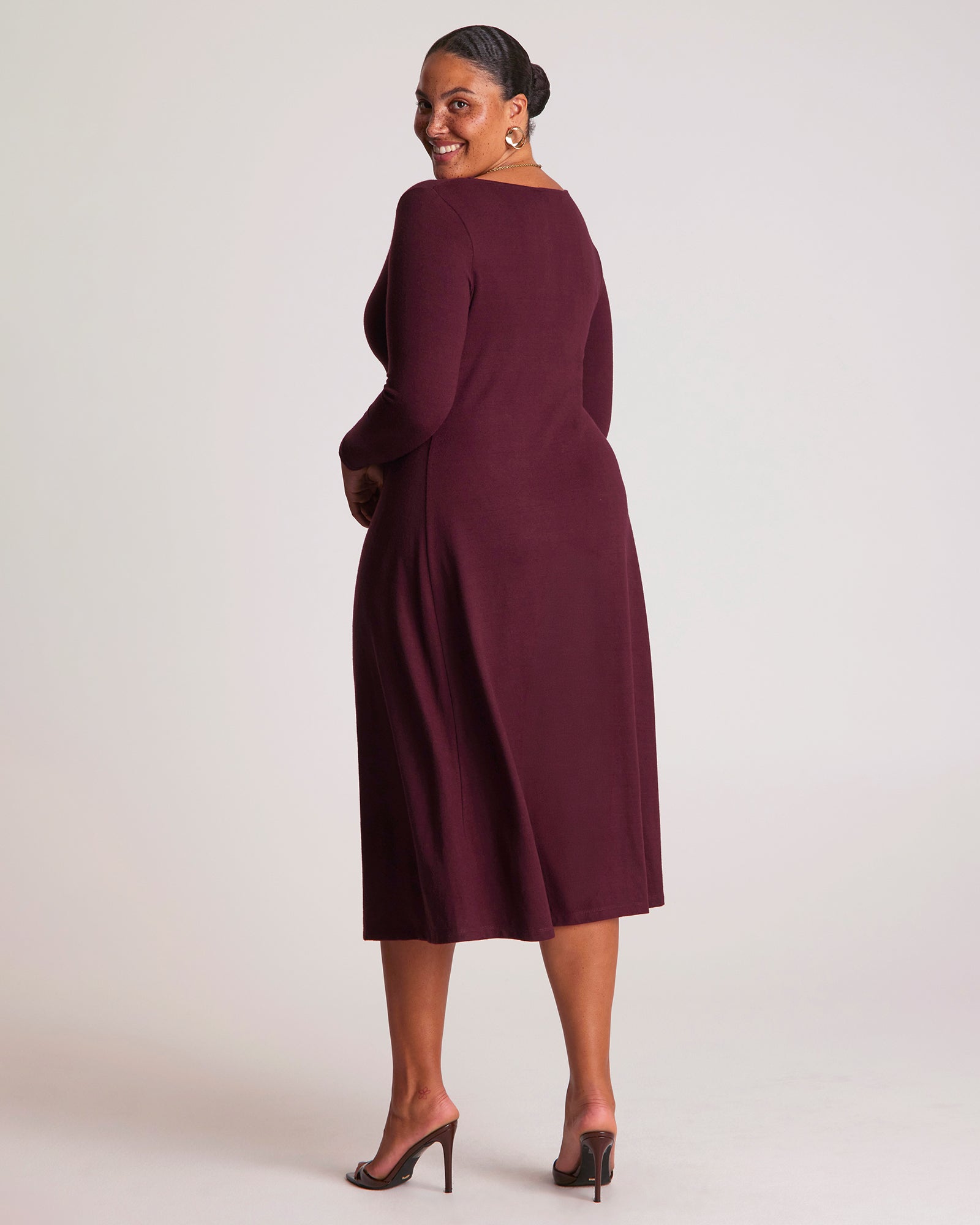 Woman wearing a burgundy dress against a white background