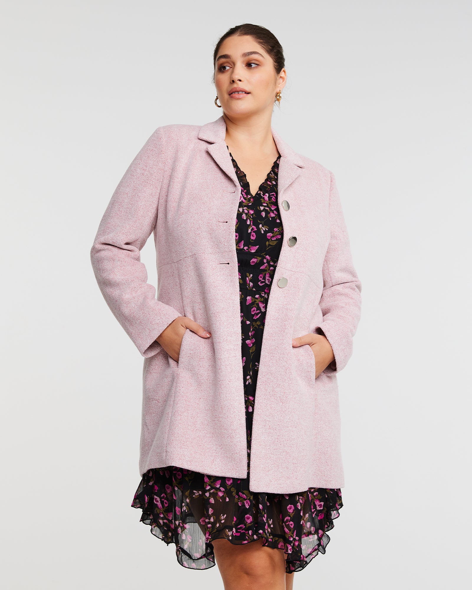 The model is wearing a Dusty Pink Collared Floater Coat by Estelle and floral dress.