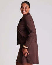 Woman wearing a brown coat against a plain background
