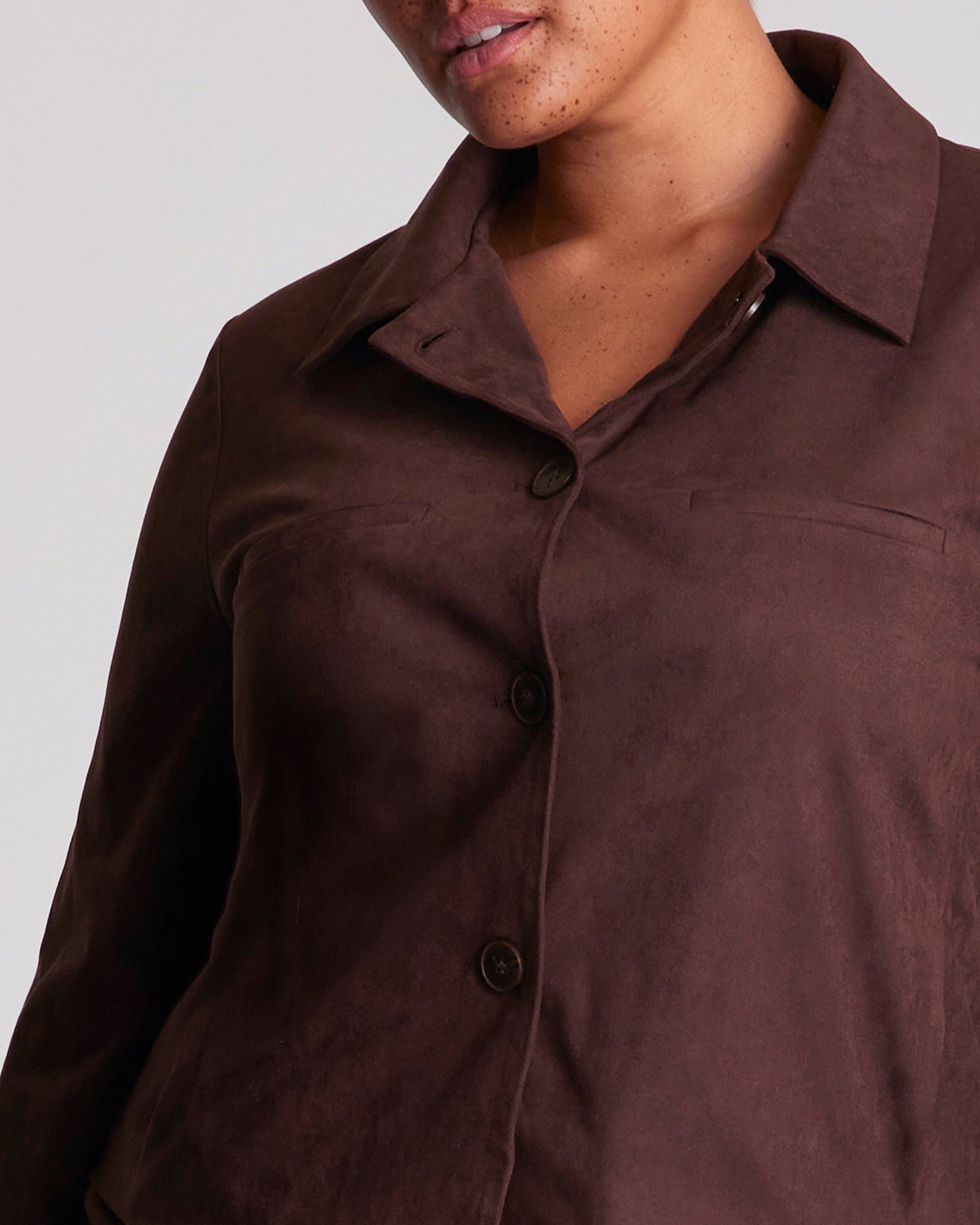 Close-up of a brown button-up shirt on a plain background
