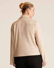 Woman wearing a beige jacket on a plain background