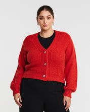 A model wearing a cozy embellished cardigan with silver buttons.