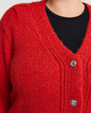 A woman wearing a cozy Embellished Cardigan with silver buttons.