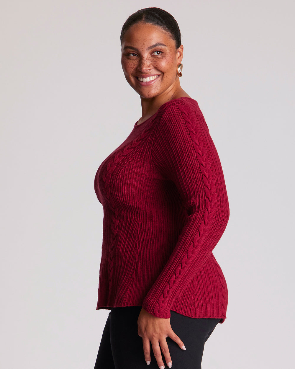 The Eveline Peplum Cable Knit Top features a classic round neckline with bind detailing and full-length sleeves for a timeless finish. Ribbed panels through the body create texture, while cable-knit detailing across the front and back adds depth and visual interest. Crafted from a soft Lyocell blend, this red cable knit top offers a distinctive silhouette with an easy slip-on design.