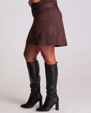 Brown suede skirt and black knee-high boots on a white background