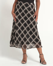 Person wearing a black and gray checkered skirt on a white background