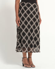 Person wearing a patterned skirt on a white background