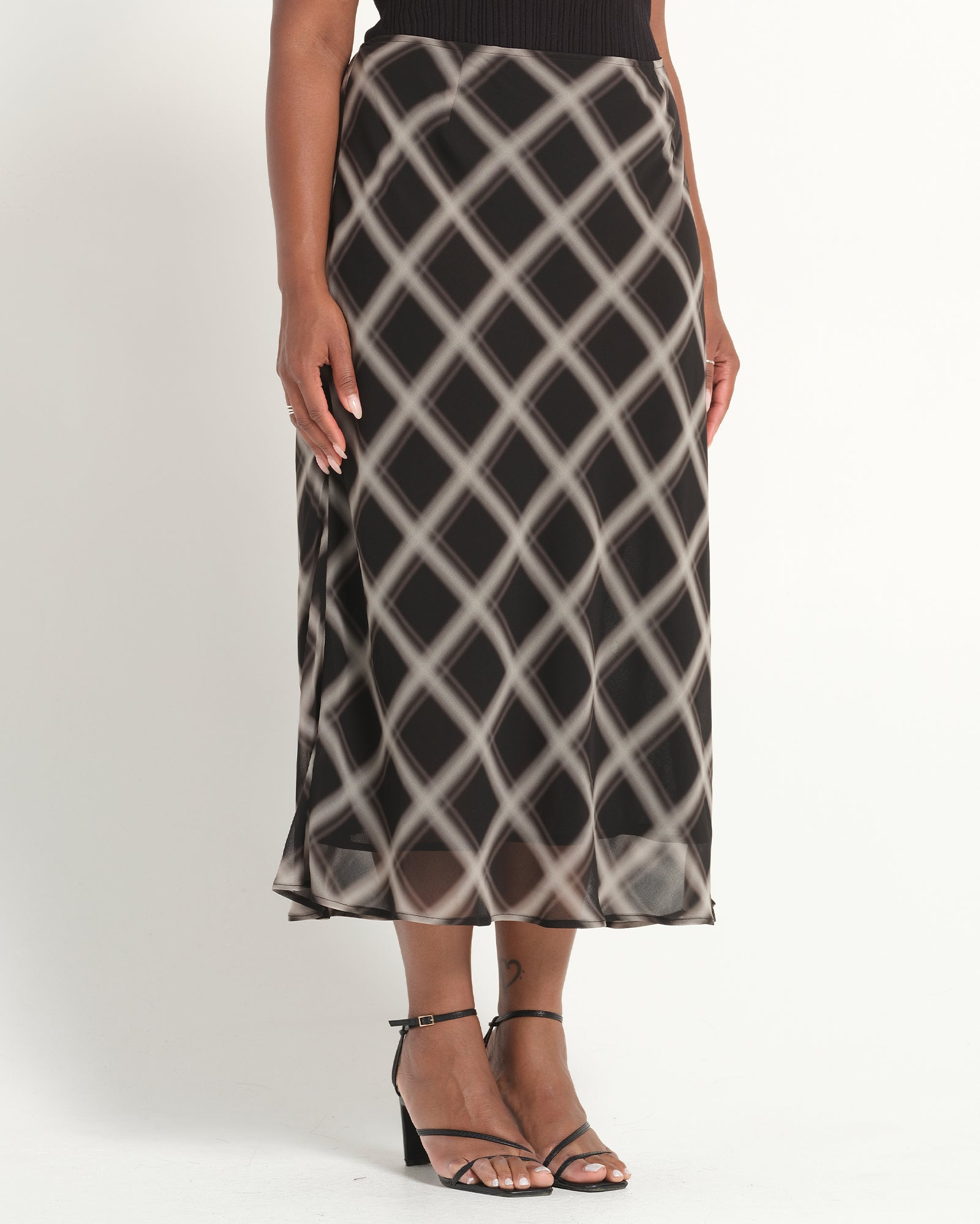 Person wearing a patterned skirt on a white background