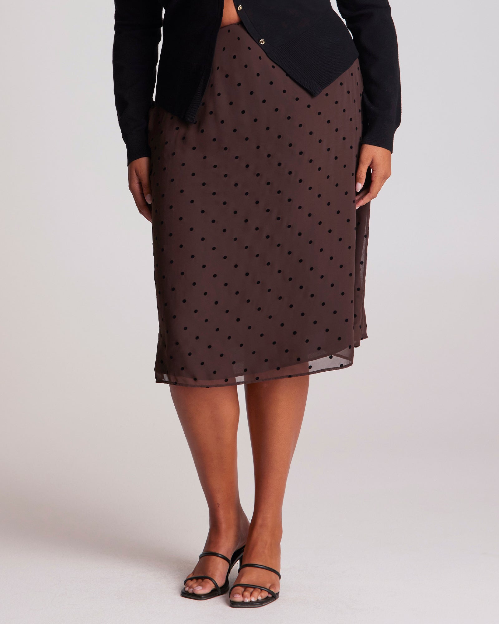 Brown polka dot skirt worn by a person on a plain background