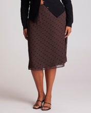 Brown polka dot skirt worn by a person on a plain background