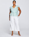 A plus size woman wearing white culottes and an Estelle Green Prairie Top.