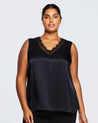A plus size woman wearing an Alessandra Black Lace Satin Camisole Top and black pants from Estelle-us brand.