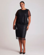 Woman wearing a black sequin dress on a white background