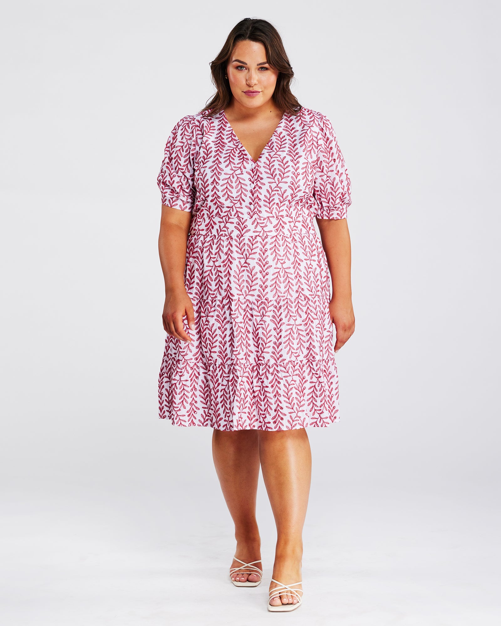 A plus size woman wearing the Estelle La Croisette Dress, a pink and white floral print dress.