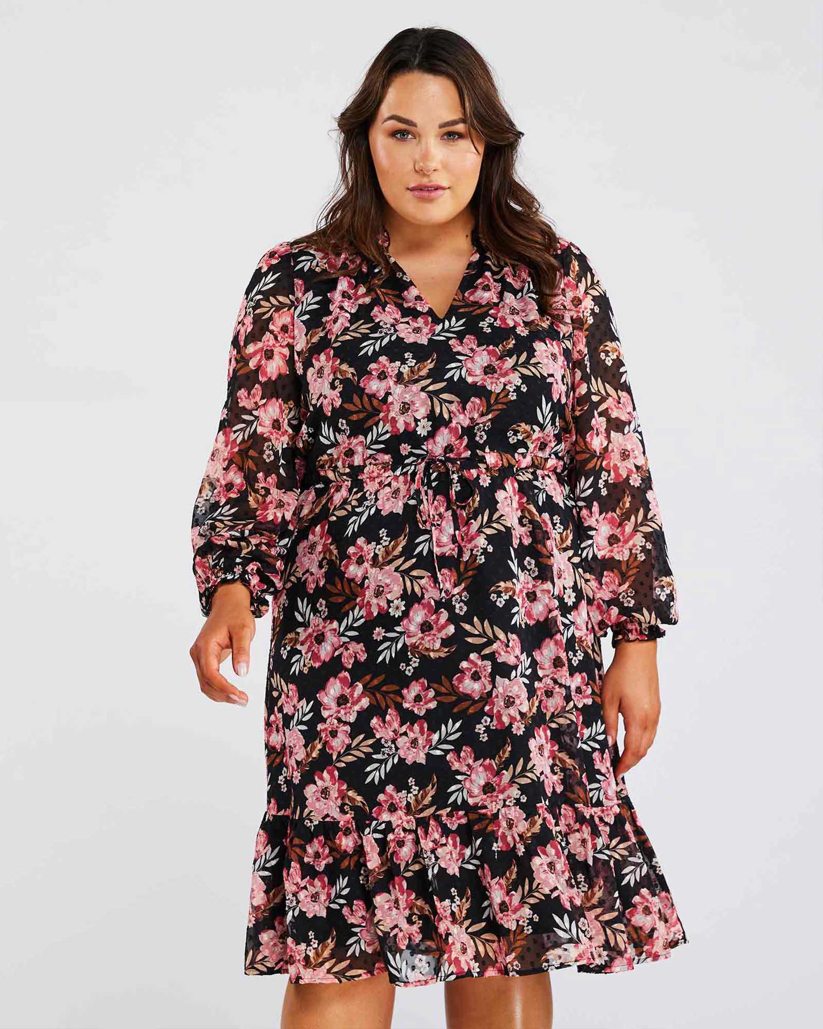 A plus size woman wearing a Woodland Floral Textured Mini Dress, perfect for her transeasonal wardrobe.