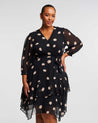 A plus-size woman donning a stylish Black Polka Dot Midi Dress with 3/4 Sleeve.