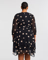 The back view of a plus-sized woman wearing a Black Polka Dot Midi Dress with 3/4 Sleeve.