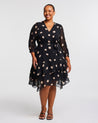 A plus-sized woman in a Black Polka Dot Midi Dress with 3/4 Sleeve.