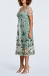 A woman wearing the Estelle Leon Embroidered Mesh Dress with a floral print.