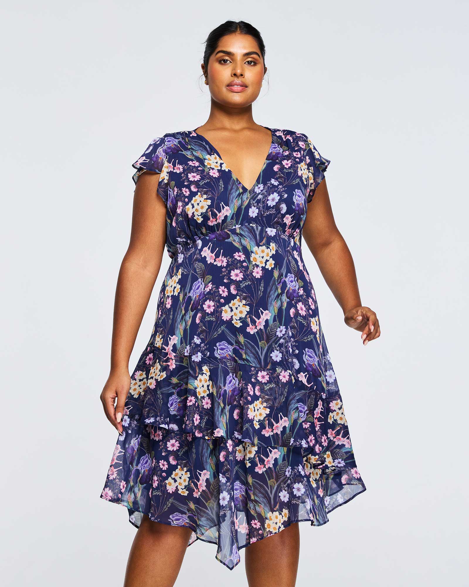 A plus size woman wearing Estelle's Botanical Purple Garden Knee Length Dress.