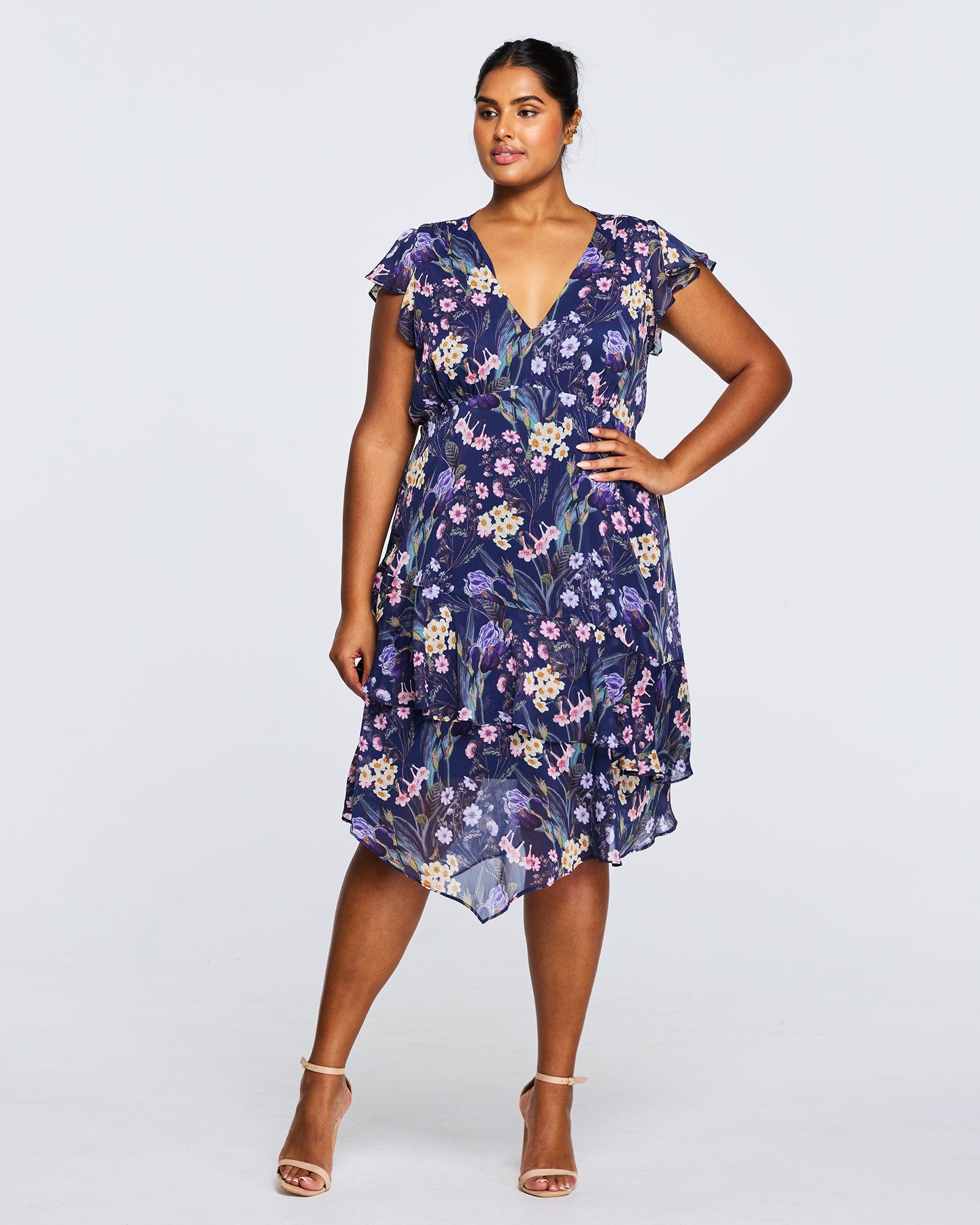 A plus size woman wearing the Estelle Botanical Purple Garden Knee Length Dress.